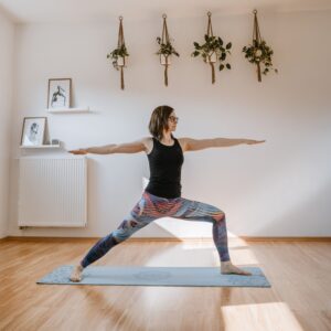 osoba praktykująca jogę asana wojownik